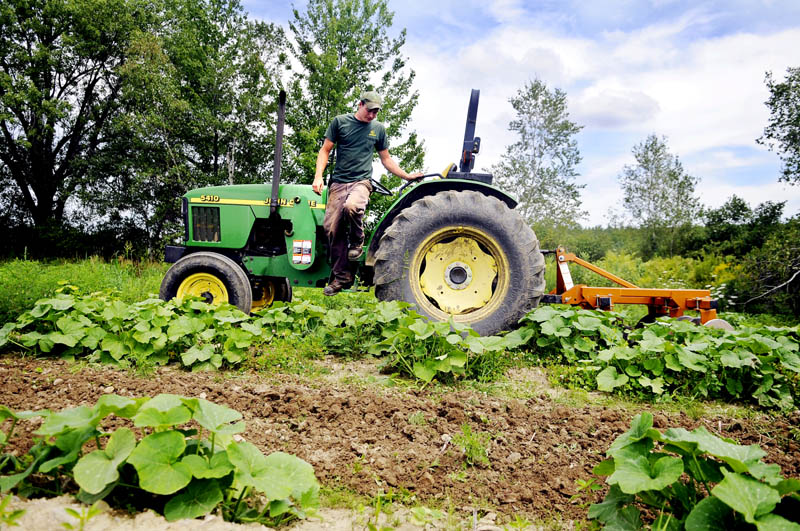 CHANGE IN PLAN: Steve Christianson dismounts a tractor after harrowing a summer squash patch Tuesday in Mount Vernon. The manager of Belle Vue Farm, in Readfield, was relieved to learn that the federal government Wednesday scrapped plans to require farmers to get commercial drivers licenses to operate their tractors.