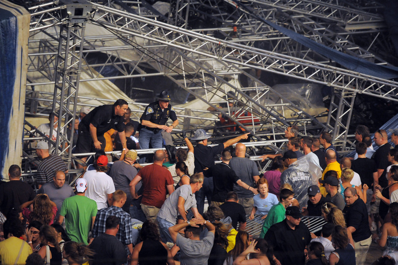 Fans waiting to see Sugarland attempt to hold up the stage after high winds blew the stage over at the Indiana State Fair Grandstands, Saturday in Indianapolis. Five people were killed.