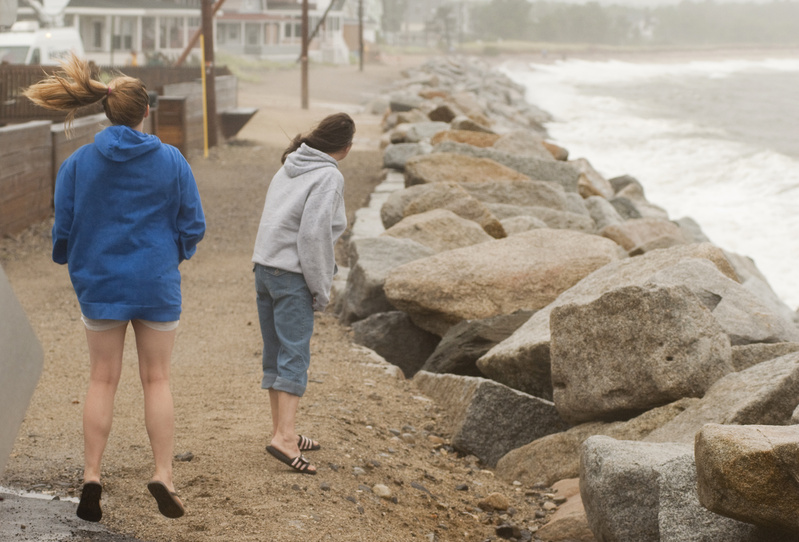 Alisha Bergeron, 17 of Saco jumps to get a better look while checking out the waves with her mother Kathy at high tide during Tropical Storm Irene along Surf Street in Camp Ellis, Saco, today.