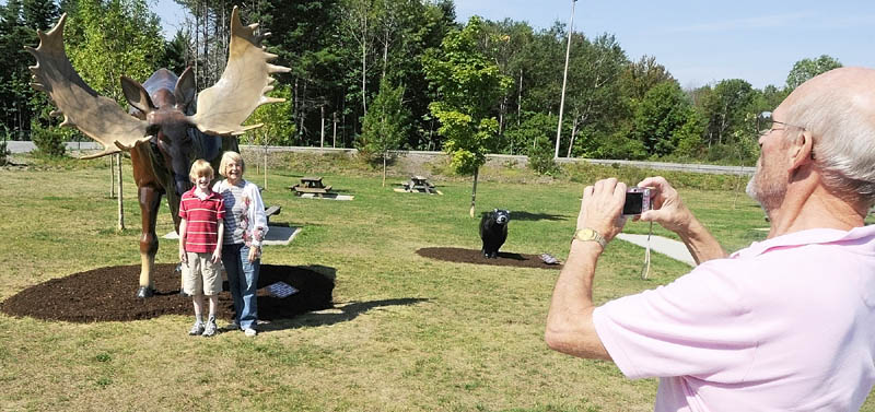 Benjamin Hagle, of Bar Harbor, left, and Nancy Ottman, of St. Paul, Minn., pose in front a Fiberglas moose as Jim Hagle, of Nashville, Tenn., snaps their picture on Thursday morning at the West Gardiner Service Plaza on Route 126 that serves both Interstate 95 and the Maine Turnpike.