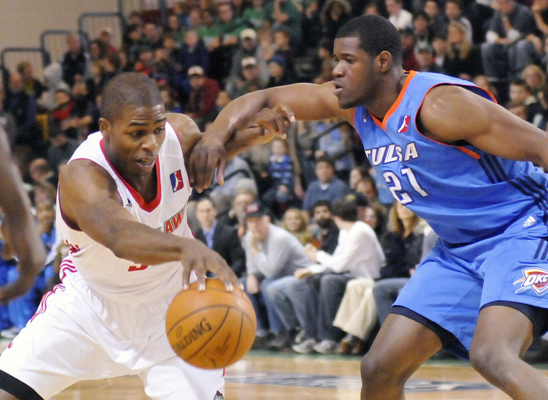 Maine Red Claw DeShawn Sims, left, fights off a Tulsa player in this January 2011 game. The franchise has sold out every game in its first two seasons at the Portland Expo, averaging 3,045 fans a game.