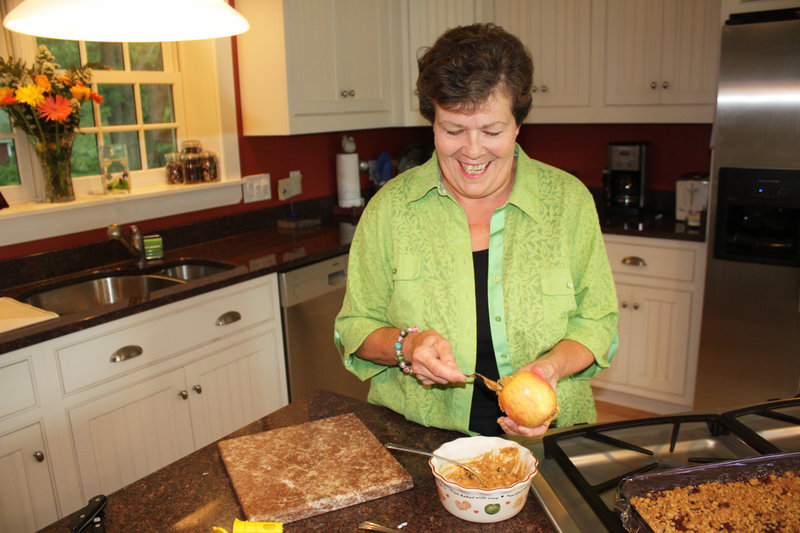 Vesta Rand stuffs a cored apple with a mixture of peanut butter, dried fruit, nuts and seeds in her Yarmouth kitchen for her prize-winning Mackworth Island Walking Salad.