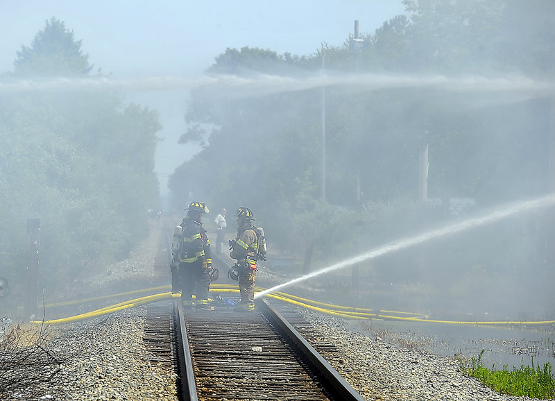 Firefighters shoot a stream of water from the railroad tracks to the Galaxy nightclub. A recent inspection of the building found a few minor wiring problems, but nothing unusual.