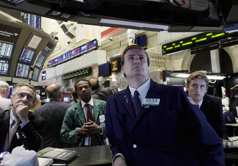 Patrick King, second from right, and others watch President Barack Obama’s remarks on a television monitor from the floor of the New York Stock Exchange on Tuesday.