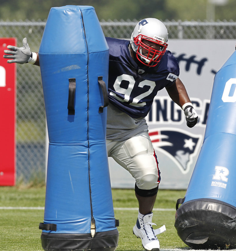 Albert Haynesworth takes on a tackling dummy during a training camp workout Tuesday at Foxborough, Mass. The Patriots acquired him from the Redskins to take on opposing quarterbacks this season.