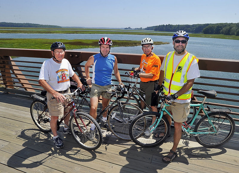 From left, Tom Daley, founder and trustee for Scarborough Eastern Trail Alliance; Stewart; John Andrews, retired president and founder of the Eastern Trail Alliance; and Hamblen pause to celebrate after crossing the bridge over the Scarborough Marsh.