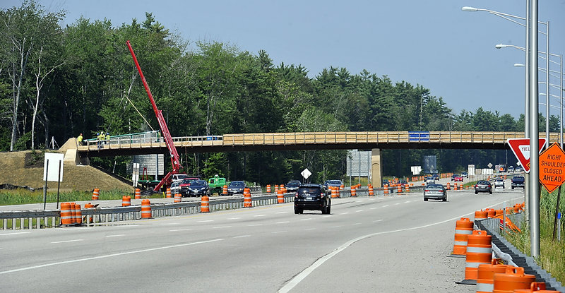 A rail is lowered into place as work on the Eastern Trail bridge over I-95 continues.