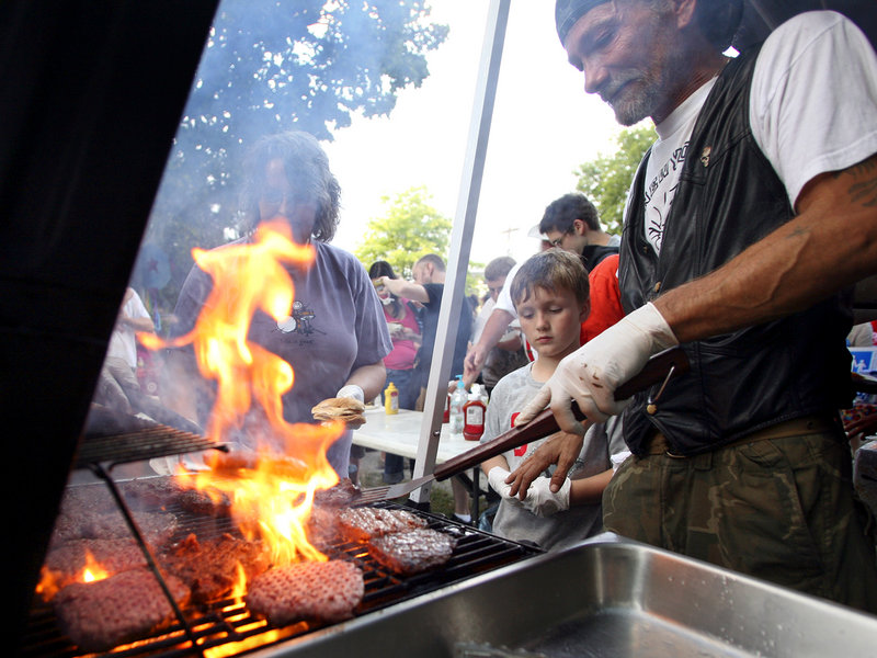 Bill Sidelinger, an East Bayside resident, grills burgers in Peppermint Park Tuesday as part of National Night Out. This is a good way to show the children that the neighborhood they live in is safe, said resident Ann Marie Tucker.