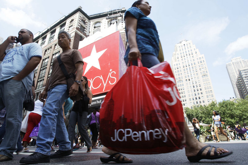 Shoppers pass Macy’s department store Thursday in New York. Discounts and sweltering heat in July drove back-to-school bargain hunters to air-conditioned malls.