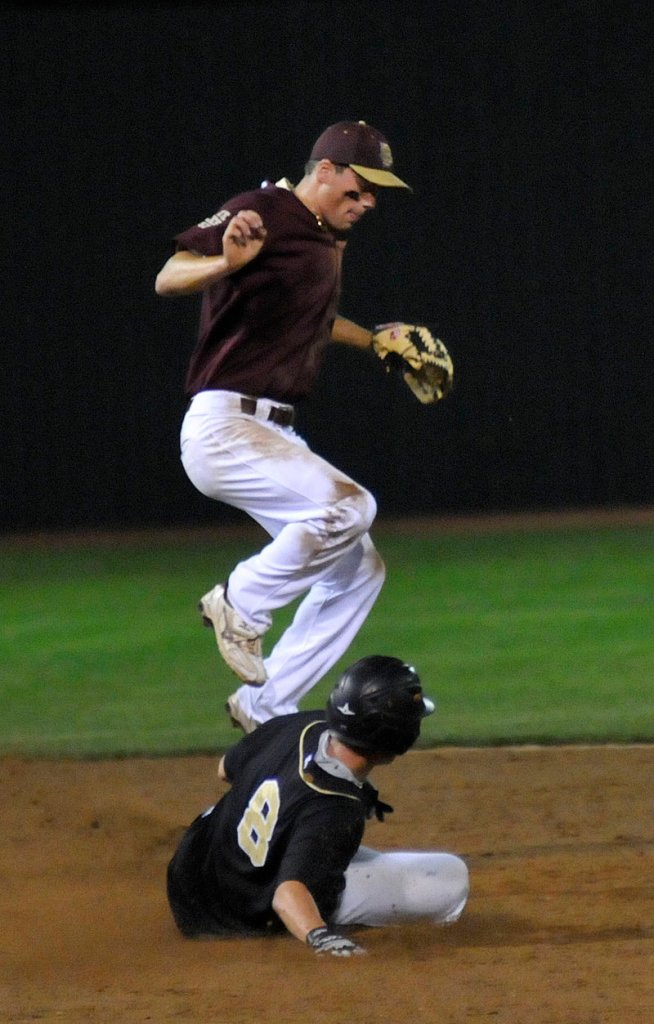 Sam Canales of Fayette-Staples, the host team, leaps as Nick Ferguson of Colchester, Vt., steals second base.