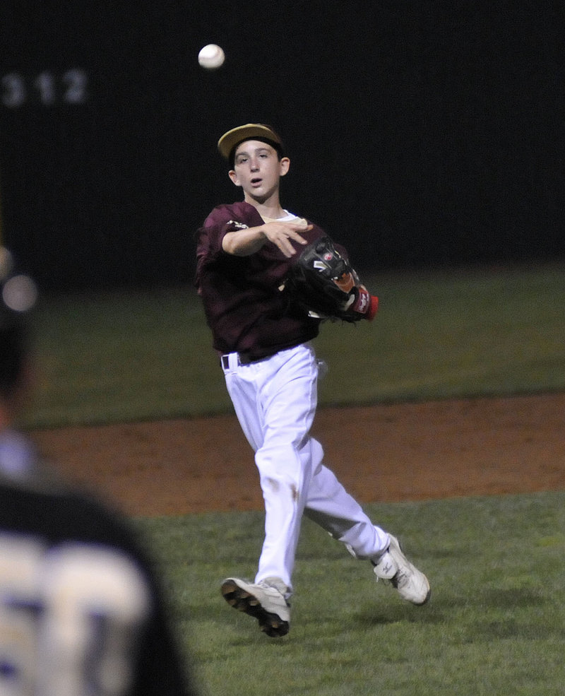 Ryder Kenney of Fayette-Staples keeps his concentration while unleashing a throw to first base to get the runner.