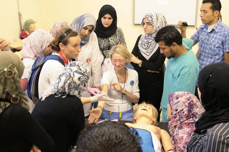 Elizabeth McLellan, center, and Sophie Belanger, left, show Libyan medical students in Benghazi how to properly insert an IV into a patient’s arm. McLellan is the founder of Scarborough-based Partners for World Health.