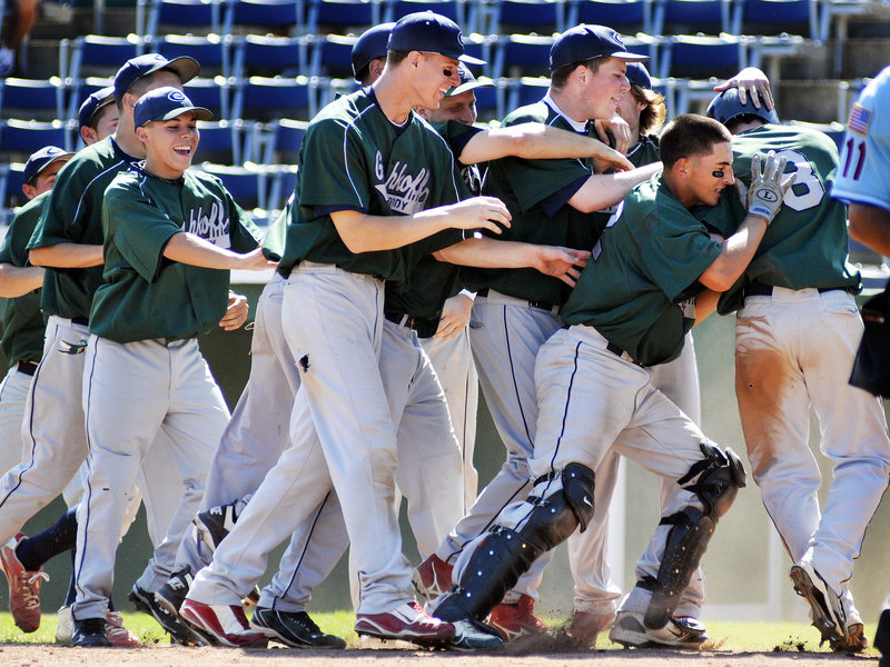 Matt Pagano is mobbed by his teammates Friday after scoring the winning run for Cranston, R.I., in the 10th inning in a game that eliminated host team Fayette-Staples from the American Legion Northeast Regional at The Ballpark in Old Orchard Beach. Mike Hayden s sacrifice fly won it.