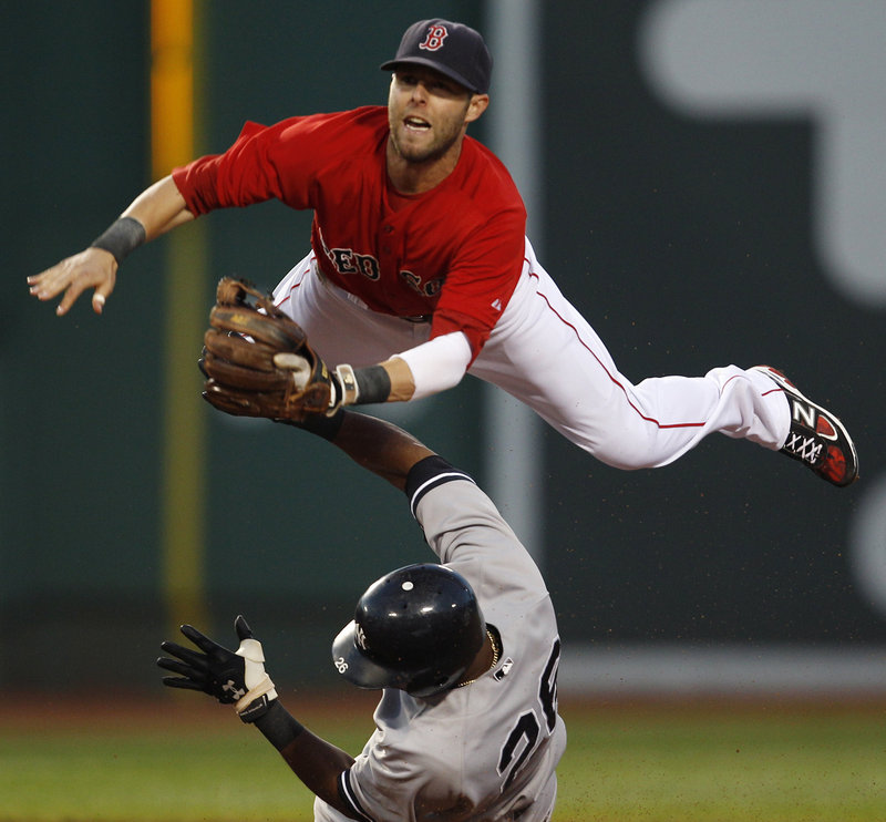 Dustin Pedroia of the Boston Red Sox leaps over Eduardo Nunez of the New York Yankees and fires to first in the third inning Friday night. Nunez was out on a force but Derek Jeter beat the throw to first.