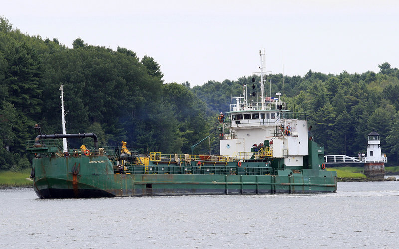 Spectators watch a dredger deepen a channel in the Kennebec River, upstream from the Doubling Point Light in Arrowsic on Friday. The Army Corps of Engineers began the work after the BEP and a federal judge rejected petitions to stop it.