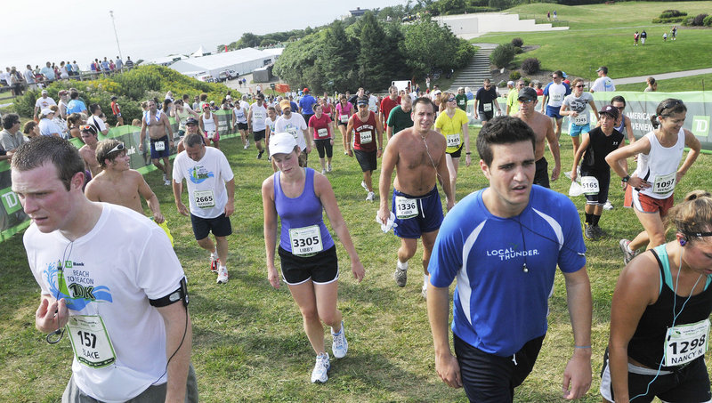 The race is over – a race held in muggy conditions – and the Beach to Beacon runners at Fort Williams in Cape Elizabeth head up a hill to the water stations for a well-deserved drink.