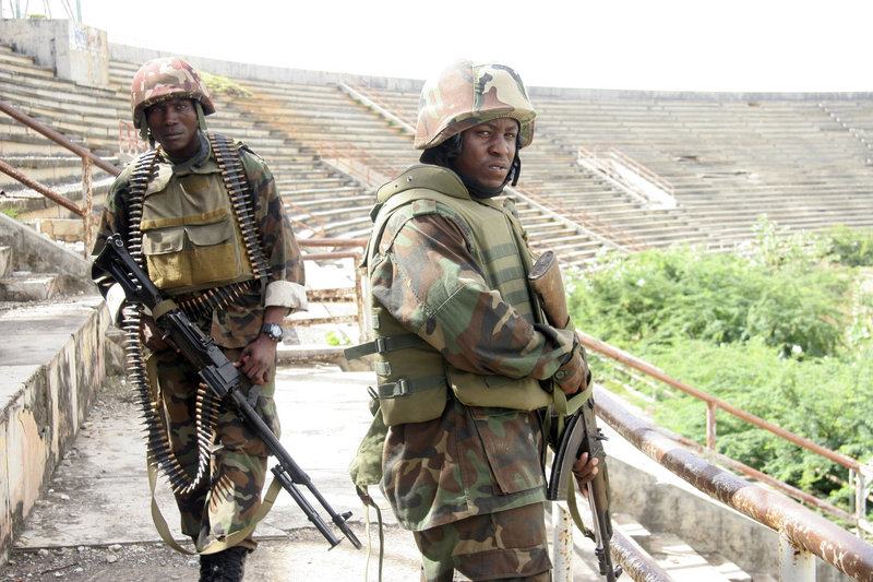 Ugandan peacekeepers and Somali government troops stand guard inside the Mogadishu, Somalia, sports stadium. The stadium was a base for al-Shabab Islamist militants until early Saturday, when al-Shabab withdrew from their bases throughout Mogadishu.