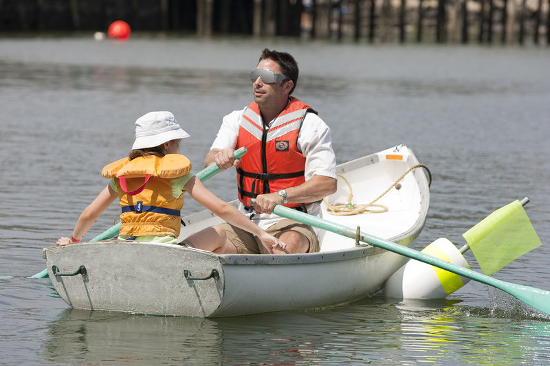 Daughter Bella guides blindfolded Vinny Lesinski of Rowley, Mass., during the Blindfold Rowboat Race.