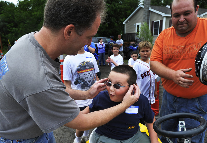 Jonathan Schomaker’s eyes light up as the 7-year-old tells his father, Jon, about his driving in the tractor pull.