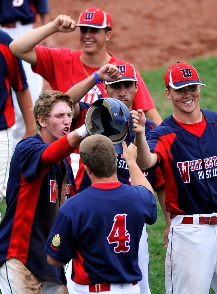 Brendan Heitz, front, is congratulated by his teammates after scoring a run Sunday to help Whitestown, N.Y., break open its elimination game with Norwalk, Conn. Whitestown won, 9-5.