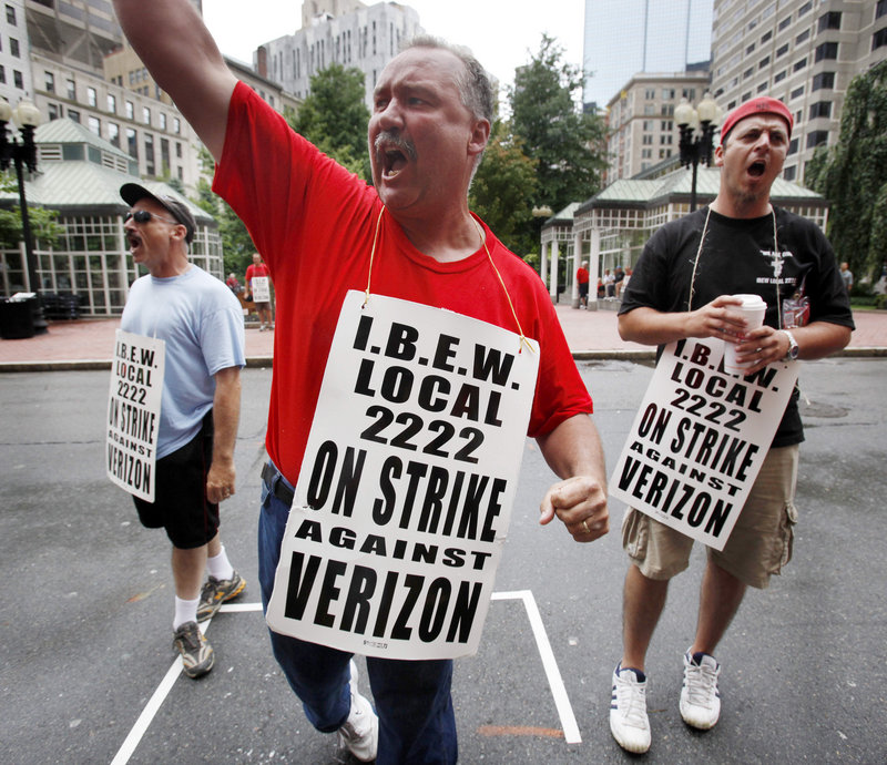 Verizon worker PJ Foley, center, of Quincy, Mass., leads a chant while picketing outside a Verizon headquarters in Boston on Sunday. About 45,000 Verizon workers, from Massachusetts to Washington, D.C., went on strike Sunday.