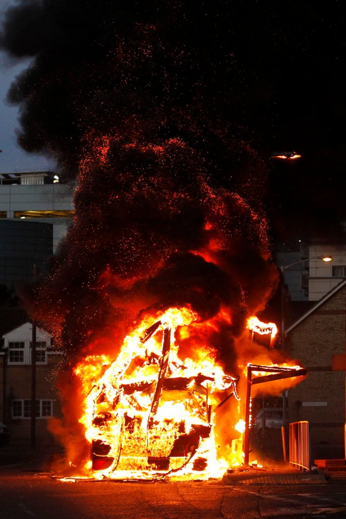 A bus burns as rioters gather in Croydon, south London, on Monday. Violence and looting spread across some of London’s most impoverished neighborhoods on Monday.