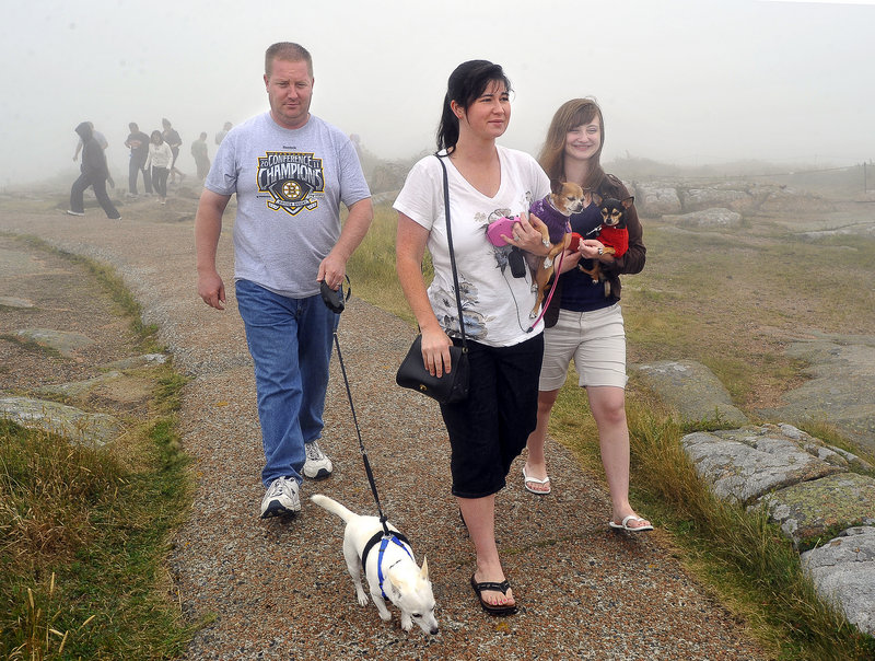 Richard Weiss, left, of Maryland walks Buddy as his wife, Jennifer, holds Keety and her sister Emily Rosenthal, 15, holds Melvin during a visit to Cadillac Mountain.