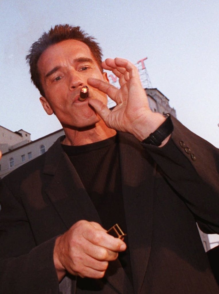 Arnold Schwarzennegger enjoys a cigar in 1996.