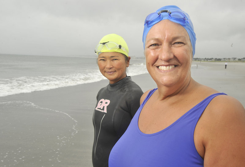 Pat Gallant-Charette, right, of Westbrook was inspired to become a distance swimmer after the death of her brother. Yoko Aoshima of Falmouth, who joins Gallant-Charette during her training sessions at Pine Point Beach in Scarborough, has been similarly inspired by her swimming partner.
