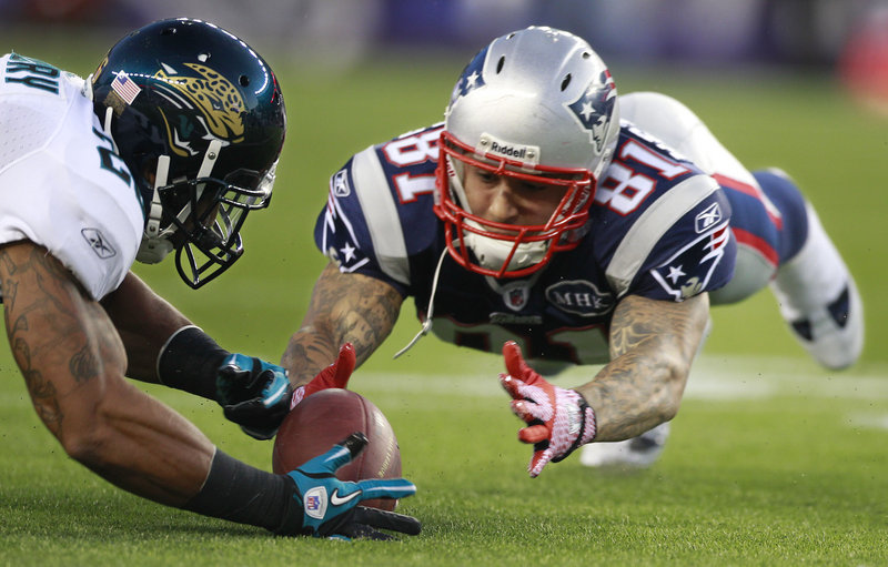 Tight end Aaron Hernandez of the New England Patriots dives for the ball after losing it Thursday night. Too late. Cornerback Rod Isaac of Jacksonville recovered the fumble.
