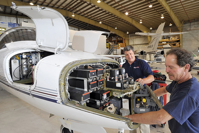 Travis Caruso, left, director of maintenance for Maine Aviation Corp., talks with Wayne Clark, an aircraft technician, during an Inspection of a Citation 550 in the company’s maintenance hangar at Portland International Jetport.