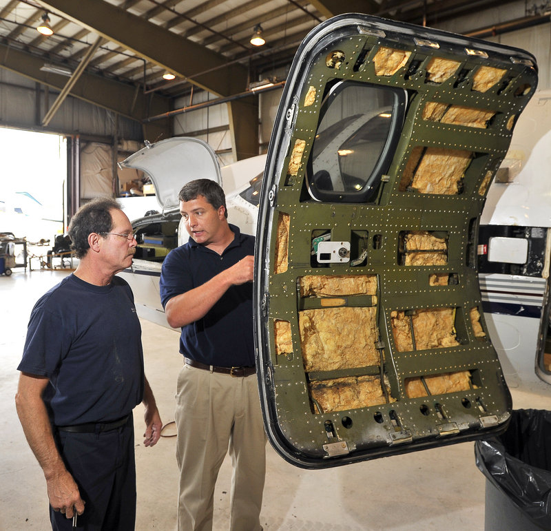 Travis Caruso, right, director of maintenance for Maine Aviation Corp., confers with Wayne Clark, an aircraft technician, during an inspection of a Citation 550 in the maintenance hangar. The company was founded by Caruso’s grandfather and great-uncle.