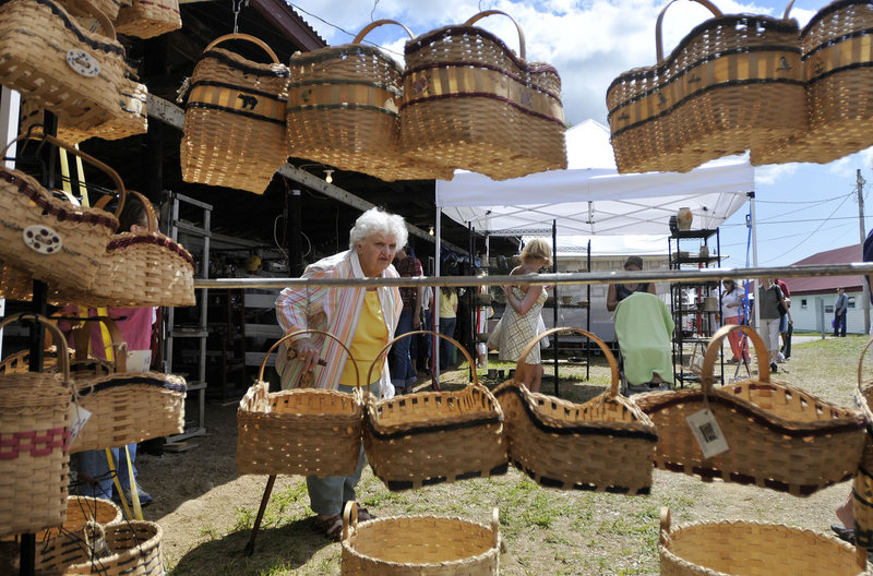 Marion Bergman of Haverhill, Mass., looks over handmade baskets by Julie Eugley of Greenfield Township during the 42nd annual Cumberland Arts & Crafts Show on Friday. The show continues today and Sunday.