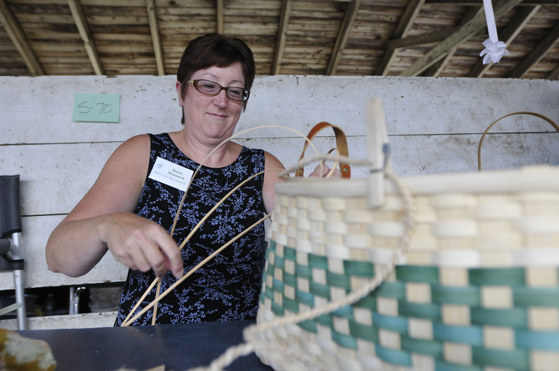 Dawn Seaward of Mountain View Baskets in Acton weaves a basket during the Cumberland Arts & Crafts Show on Friday.