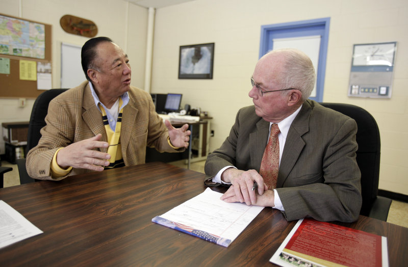 Millinocket school Superintendent Ken Smith, right, talks to Tony Yu of the U.S. China Cultural Exchange Committee last March. Local officials say they’ll stick with a plan to recruit Chinese pupils and try to expand enrollment in the years ahead.