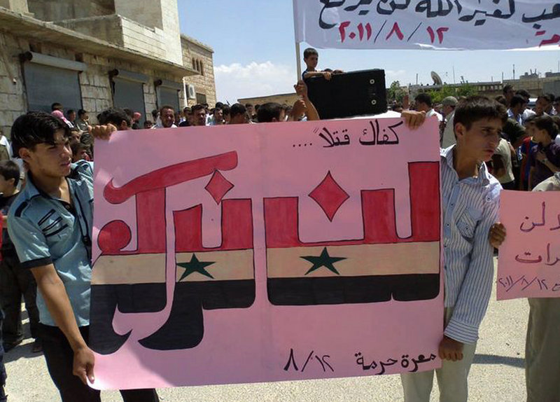 Protesters hold an Arabic banner reading “Enough killing, will not bow” during a demonstration Friday against the Syrian regime in Maarat Harma village in northern Syria. The image was taken with a mobile phone and provided by the Shaam News Network. Syria has banned most foreign journalists.