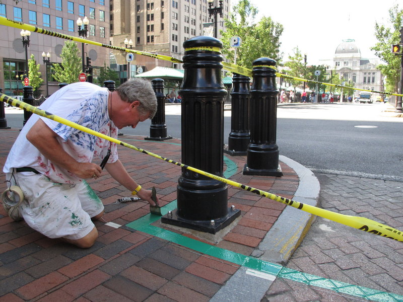 Robert Burke paints a corner of the new Independence Trail in Providence, R.I. The walking route through the city’s historic sites is set to be completed today.