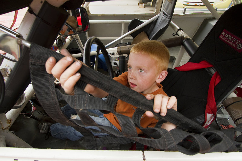 Adrien Williams, 6, of South Thomaston closes the screen on his grandfather's car during the Maine Vintage Race Car Association show on Sunday.