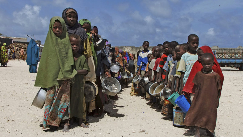 Holding their pots, children from southern Somalia line up to receive cooked food in Mogadishu on Monday. Much of the food aid being sent to Somalia doesn’t reach the starving.