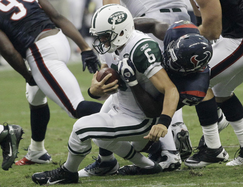 Mark Sanchez is sacked by Houston linebacker Xavier Adibi during the first quarter of the Texans’ 20-16 win Monday. New York allowed four first-half sacks.
