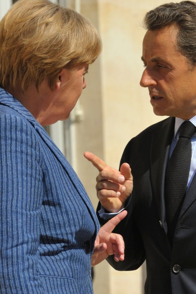 French President Nicolas Sarkozy, right, and German Chancellor Angela Merkel gesture before an emergency meeting Tuesday in Paris.