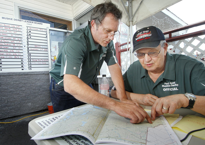 Dave Kelso, left, and Lewis “Phil” Soucy of Fort Kent talk fishing as they look over maps while volunteering at the 8th annual Fort Kent Muskie Derby. Soucy, the founder of the derby, wants to see muskie fishing grow in Maine.