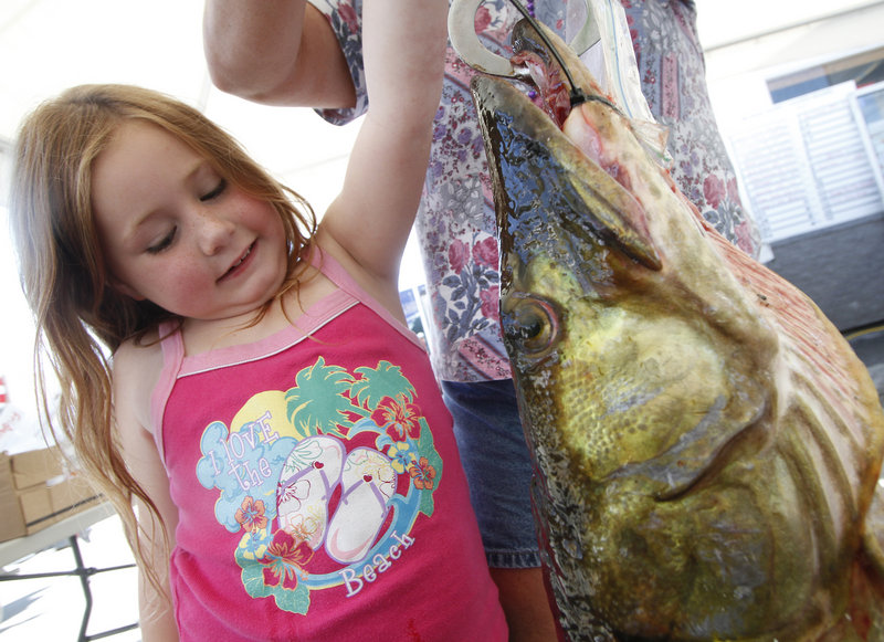 Alexis Tardie, 7, of Fort Kent hoists a 23-pound muskie with help from her mom during a visit to the derby weigh station.