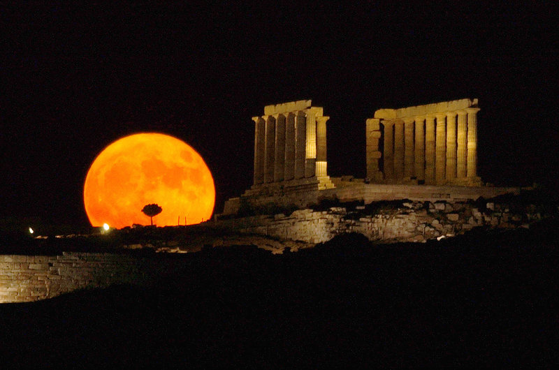 The full moon, possibly 200 million years younger than once thought, rises behind the ancient temple of Poseidon in Sounio, Greece, about 45 miles from Athens.
