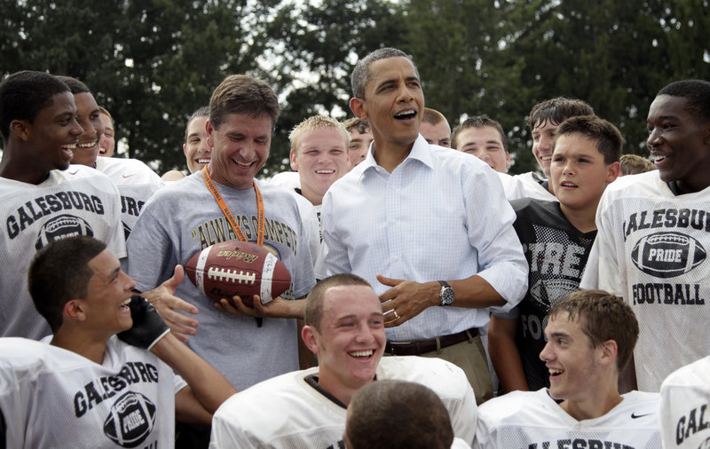 President Obama hands off a football that was tossed to him during his surprise visit Wednesday with the Galesburg High School football team in Galesburg, Ill., on the final leg of his three-state bus tour through the Midwest.