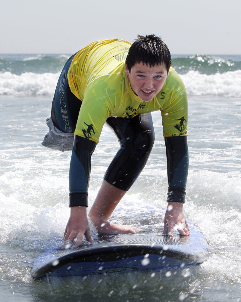 Jack Wallace, 13, surfs at Long Sands Beach in York on Thursday. Wallace traveled from New Jersey to participate in a surf clinic held by AmpSurf, an organization that teaches people with disabilities how to surf. Another clinic will he held at the same location today.