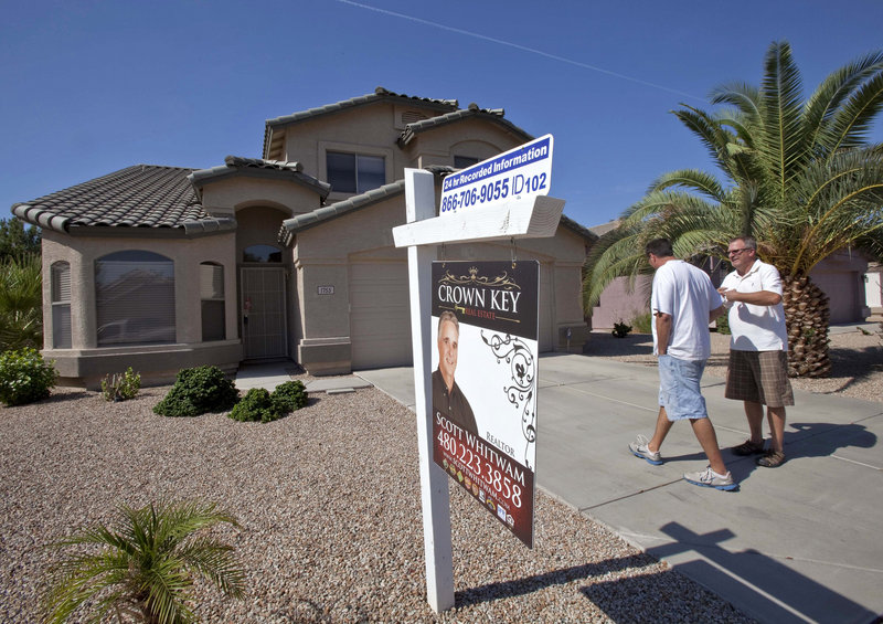 Real estate broker Kurt Sabel, right, talks with prospective buyer Ned Pierce outside a home Wednesday in Gilbert, Ariz. U.S. home sales fell 3.5 percent in July.