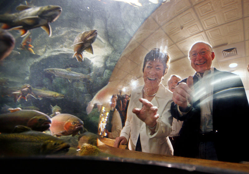 Sen. Susan Collins, R-Maine, and Interior Secretary Ken Salazar peek into an aquarium containing trout and salmon during a visit Thursday to the L.L. Bean retail store in Freeport.