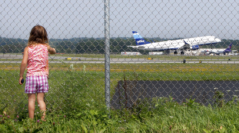 Hannah Jacob, 4, watches a JetBlue plane take off at the Portland International Jetport on Friday. She usually visits the plane-spotting area along Aviation Boulevard in South Portland twice a week with Cindy Griffin, her caregiver.