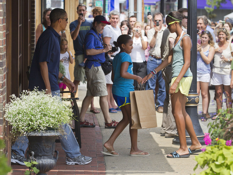President Barack Obama and daughters, Malia, 13, right, and Sasha, 10, center, leave the Bunch of Grapes bookstore Friday in Vineyard Haven, Mass. The 10-day stay on Martha’s Vineyard is his third straight summer visit to the island.